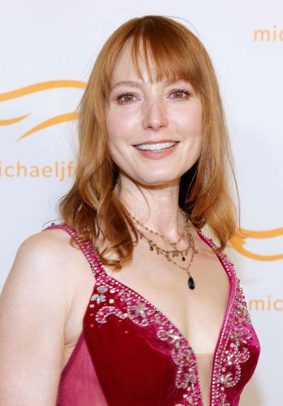 Red-haired actress posing with subtle smile