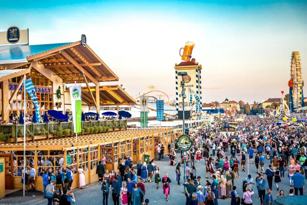 Visitors in traditional Bavarian clothing enjoying beer tents and parades at Oktoberfest in Munich.