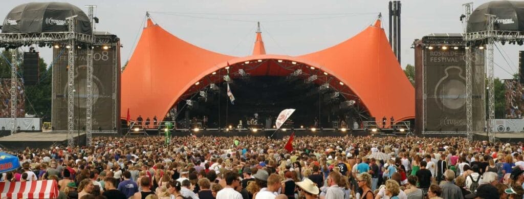 Massive crowd at Roskilde Festival in Denmark enjoying live music and cultural performances.