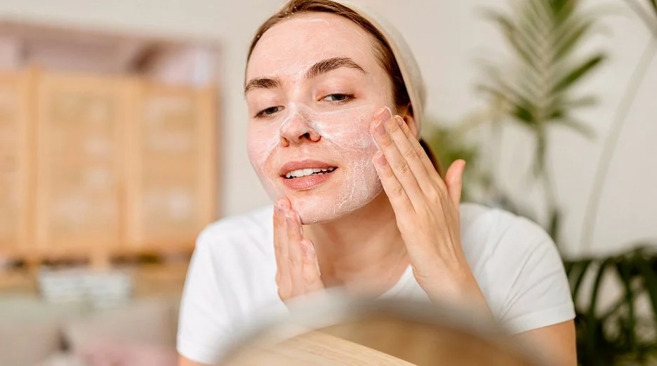 Close-up of a woman using a gentle facial cleanser with foam on her cheeks