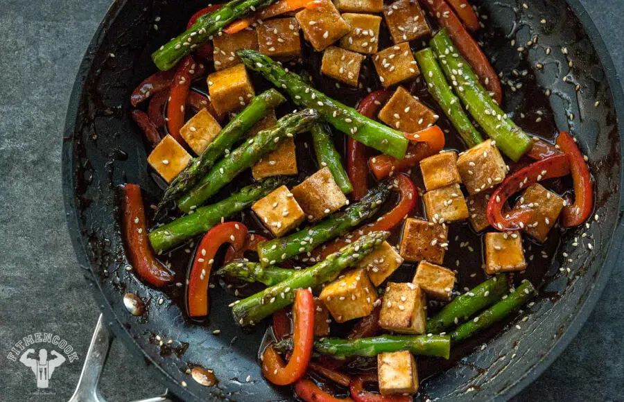 “Colorful tofu and vegetable stir-fry in a skillet with broccoli, bell peppers, and snap peas.”