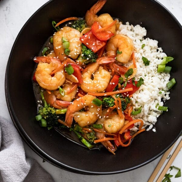 “Shrimp sautéed with colorful bell peppers and zucchini in a skillet.