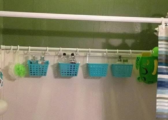 A shower curtain with clear storage pockets attached, holding bath essentials like shampoo, razors, and soap.