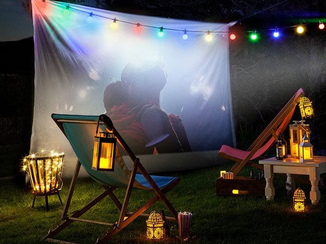 “Living room with dim lighting, fairy lights, and movie posters creating a cinematic vibe.”