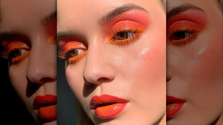 "Model with bright eyeshadow, colorful eyeliner, and vibrant lipstick, expressing playful makeup trends."