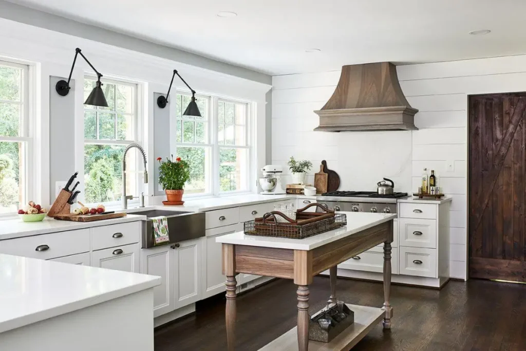 “Rustic wooden butcher block countertop in a farmhouse kitchen with vintage cutting boards and metal utensils.”