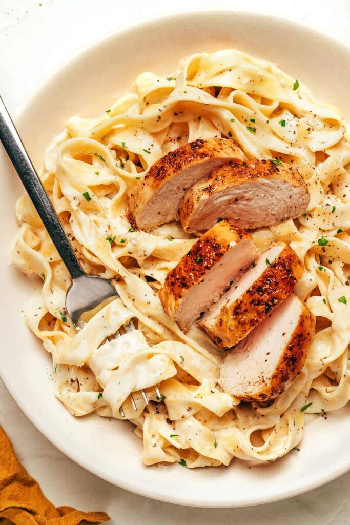 “Rich and buttery fettuccine Alfredo topped with Parmesan cheese – an easy Italian pasta dish to cook at home.”