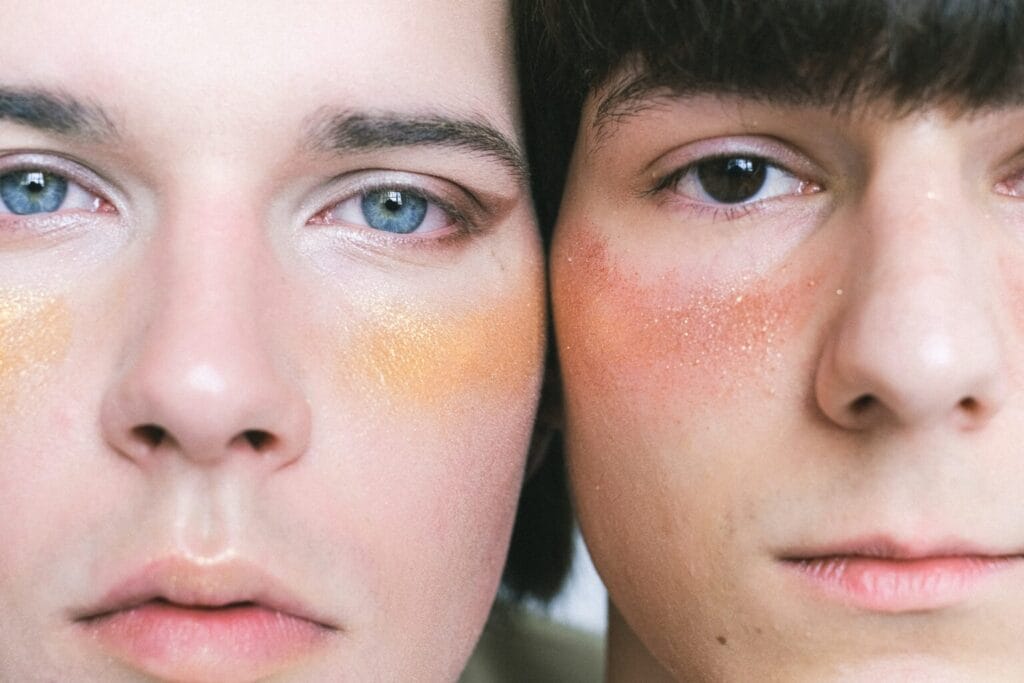 "Diverse group of models with different skin tones, genders, and facial features wearing minimal makeup."