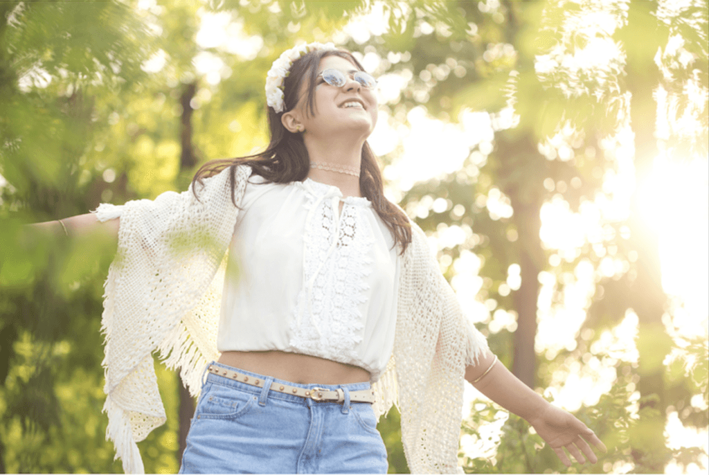 “Woman smiling confidently with natural makeup and relaxed posture.”