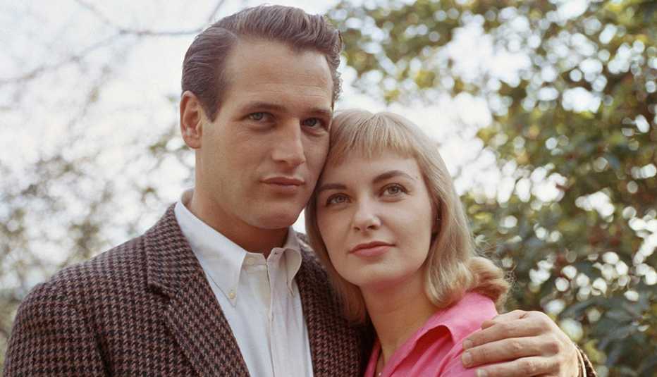 “Vintage photograph of Paul Newman and Joanne Woodward holding hands and smiling, capturing timeless Hollywood romance.”