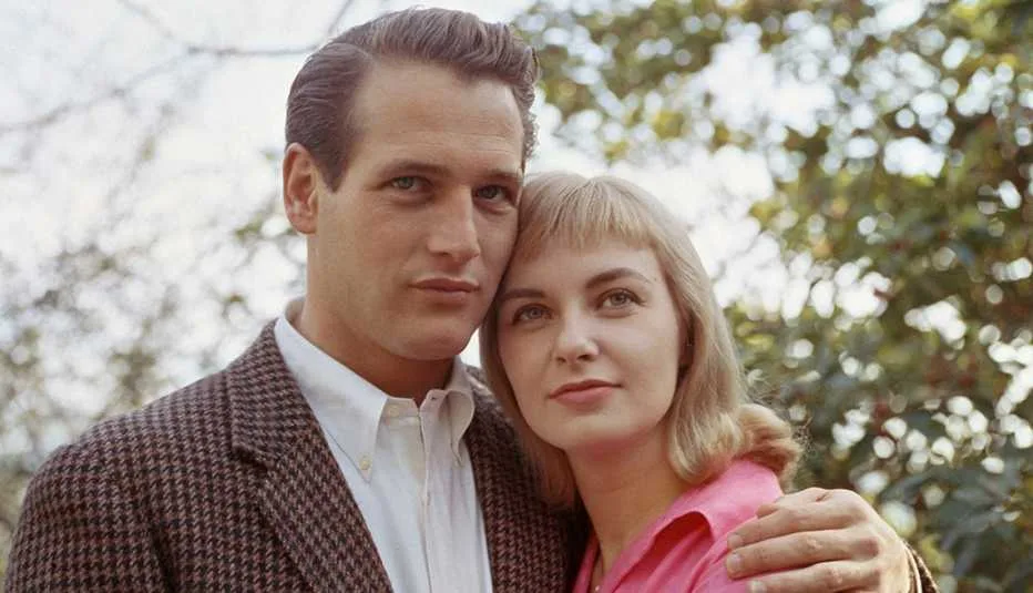 “Vintage photograph of Paul Newman and Joanne Woodward holding hands and smiling, capturing timeless Hollywood romance.”