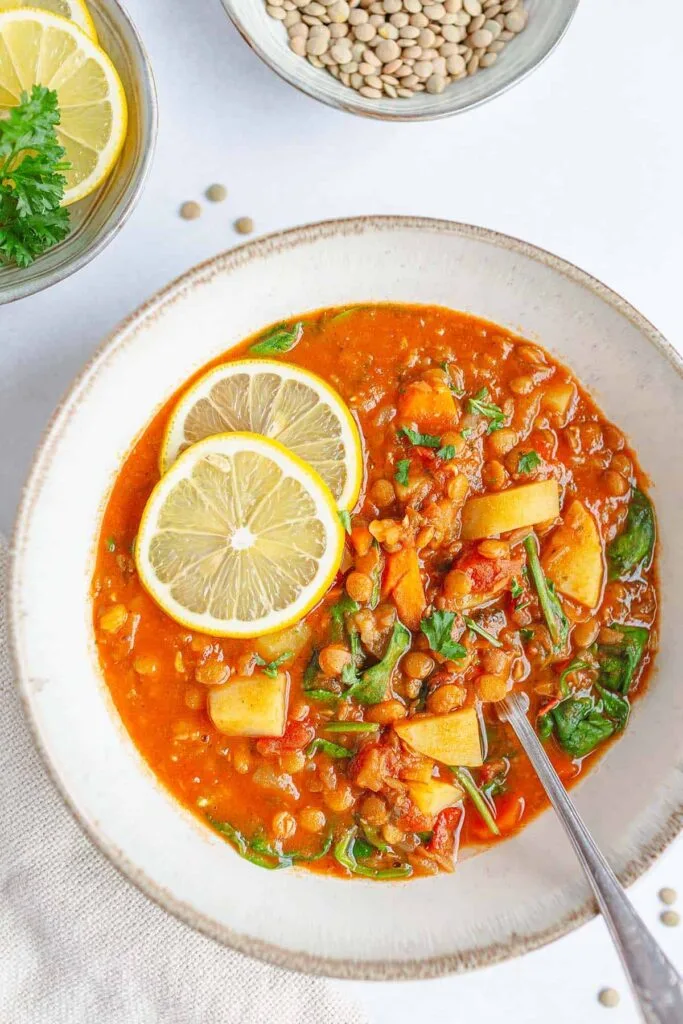 Warm bowl of homemade lentil soup with carrots, celery, and herbs.”