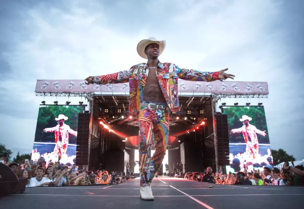 “Lil Nas X wearing cowboy attire performing ‘Old Town Road,’ symbolizing its viral TikTok meme success.”