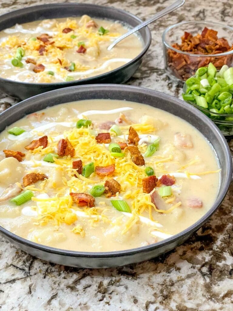Creamy potato soup topped with shredded cheddar, crispy bacon bits, and chopped chives.