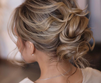 Casual messy top knot hairstyle designed for busy summer days and high humidity — Best Hairstyles to Beat Summer Humidity.