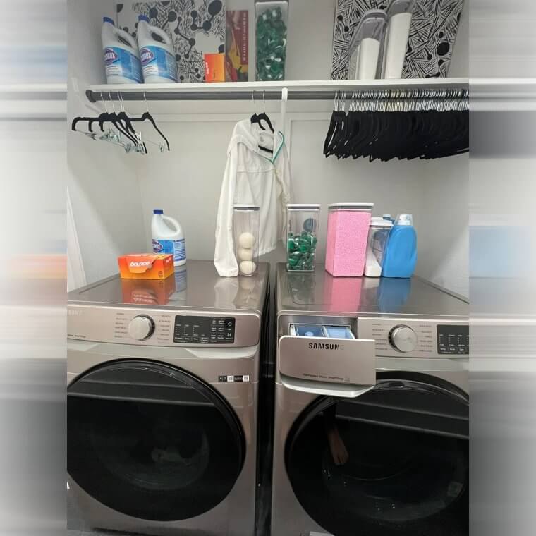 Narrow laundry space with a tension rod used for hanging clothes to dry or prep for ironing, maximizing functionality.