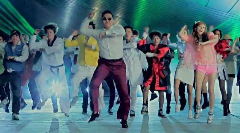 “PSY doing the Gangnam Style horse dance, representing the viral meme and YouTube sensation.”