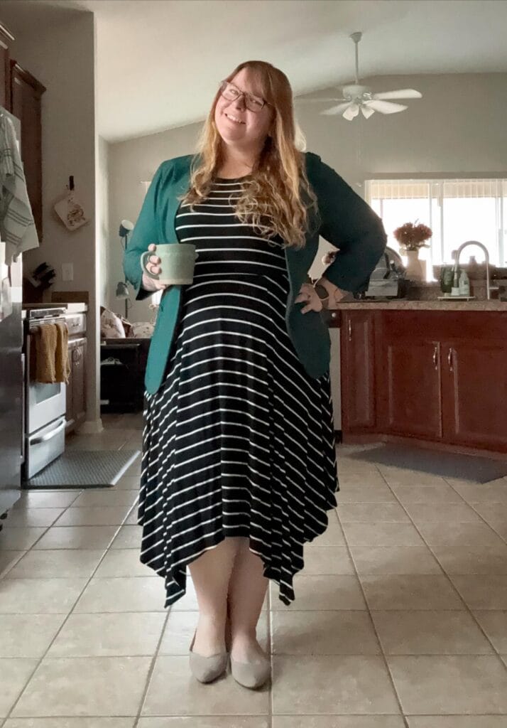 Curvy professional woman wearing tailored blazer and belted pants for plus size office outfit.