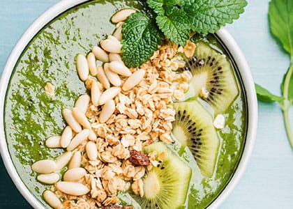 “High-protein smoothie bowl with banana, almond butter, and protein powder topped with strawberries and granola.”