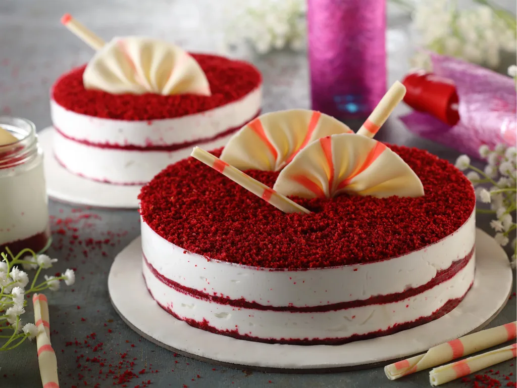 “Creamy red velvet cheesecake topped with whipped cream and chocolate drizzle for Valentine’s Day”