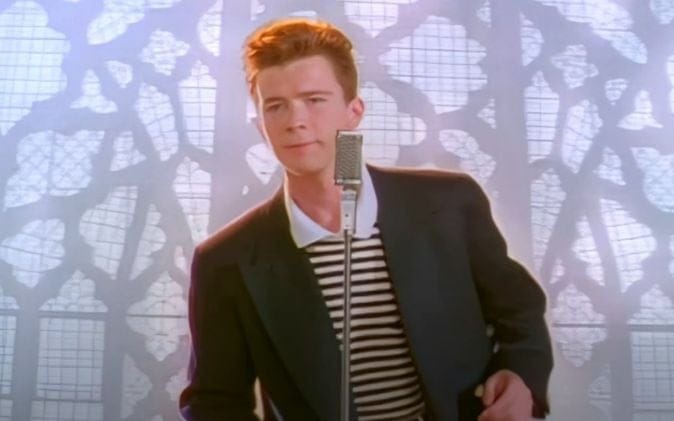 “Rick Astley performing ‘Never Gonna Give You Up,’ symbolizing the classic Rickroll internet meme.”