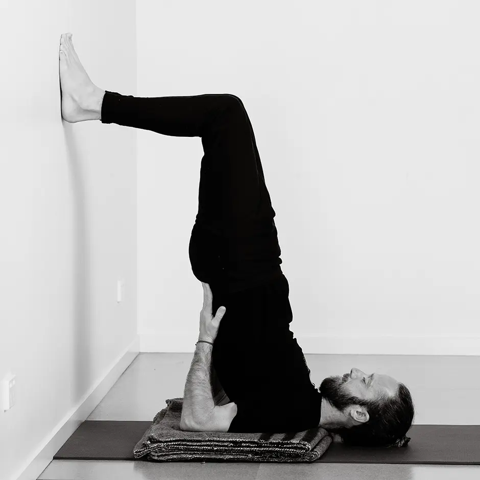“Woman performing shoulder stand yoga pose to improve complexion.”