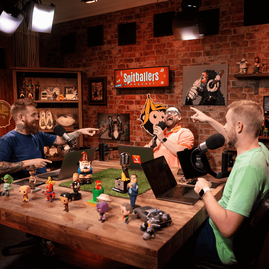 “Spitballers Podcast hosts Andy, Jason, and Mike joking together in a recording studio.”