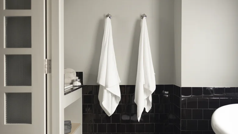 “Person gently patting skin with a soft towel after a shower instead of rubbing to prevent irritation.”