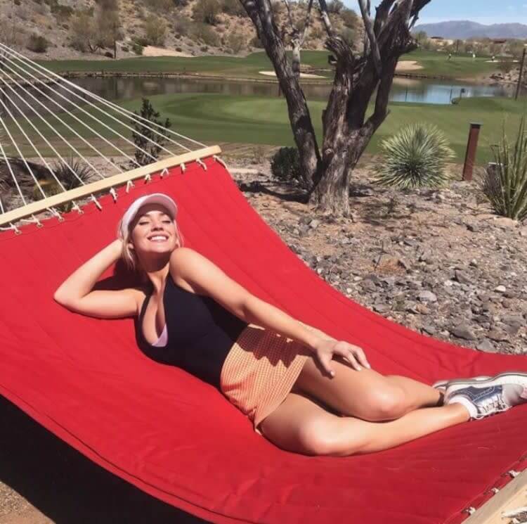 Paige Spiranac smiling at San Diego University golf practice with her new coach.