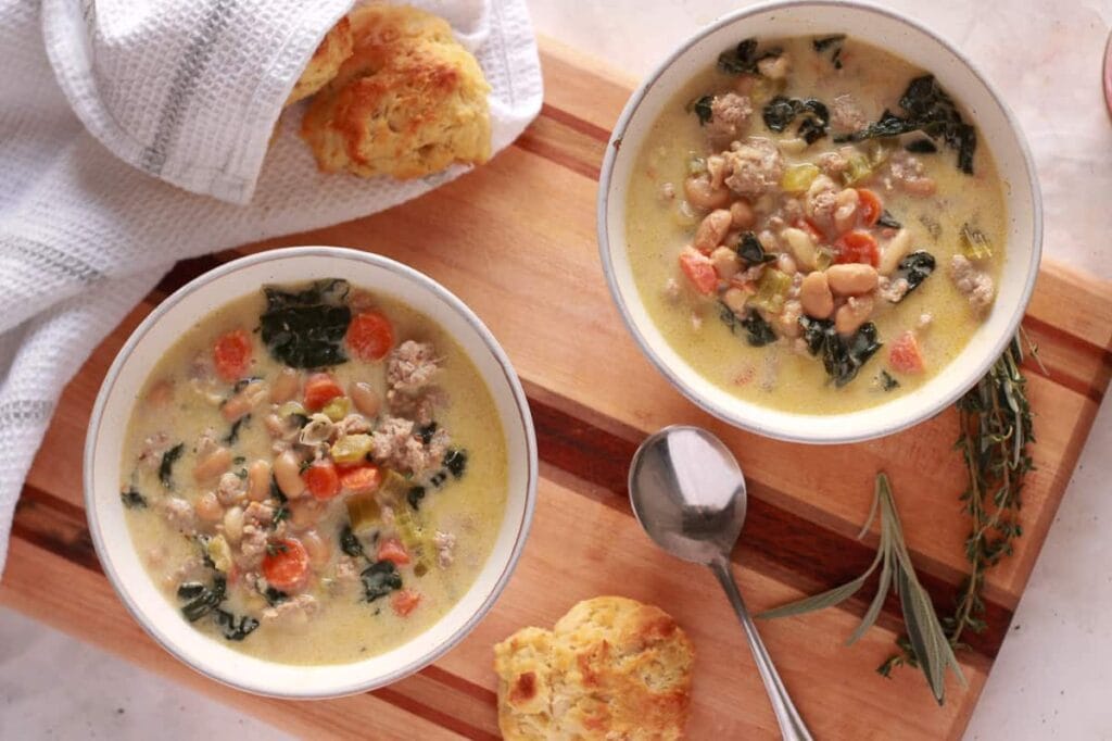 Rustic white bean and kale soup in a ceramic bowl, with visible cannellini beans and dark green kale.