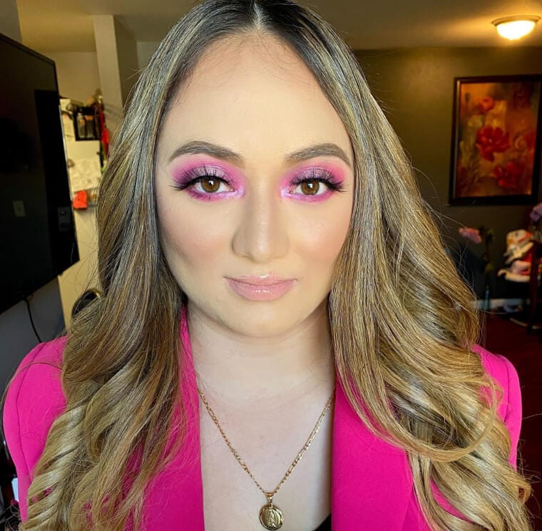 Eyeshadow palette with earthy tones being applied to eyelids matching skin tone.