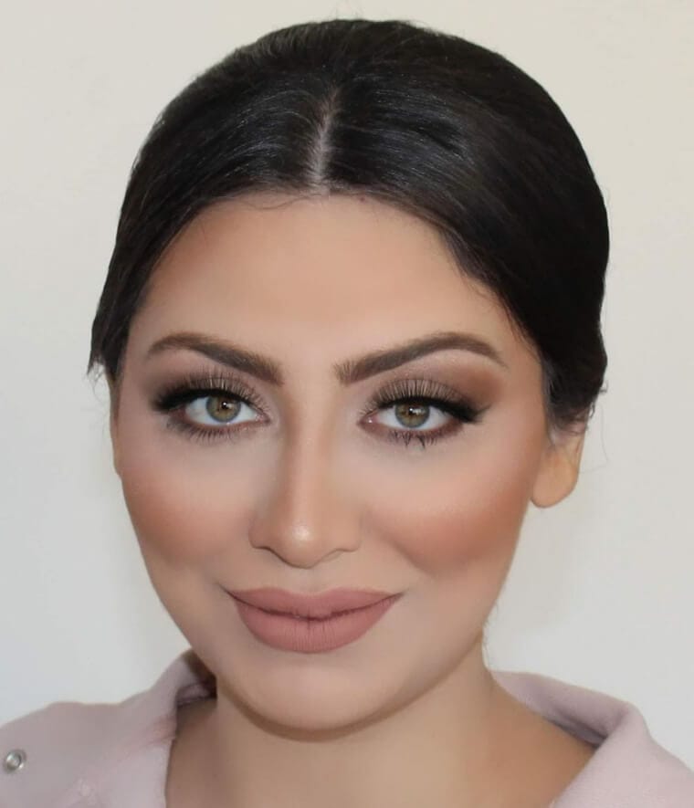 Close-up of woman applying contour makeup with brush, showing natural and well-blended look.
