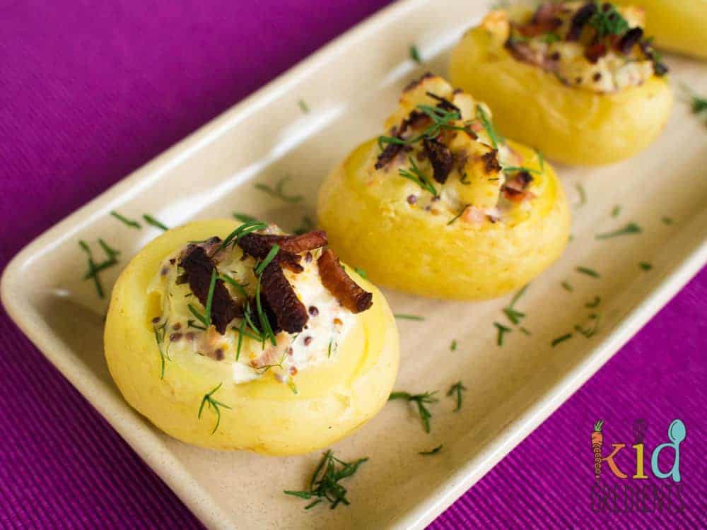 “Mini baked potato bites with cheese, bacon, and sour cream for New Year’s Eve snack table.”