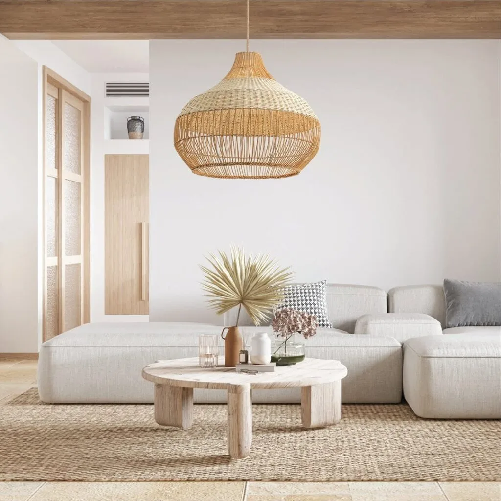 Minimalist living room with an open-weave rattan pendant light, jute rug, neutral sectional, and rustic wood coffee table.