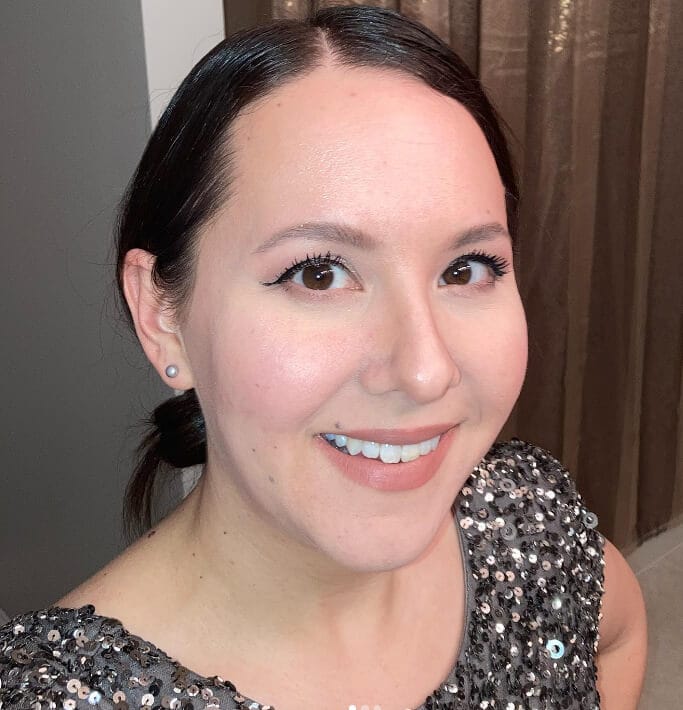 Woman applying small amount of liquid foundation evenly across face for smooth, natural skin tone.
