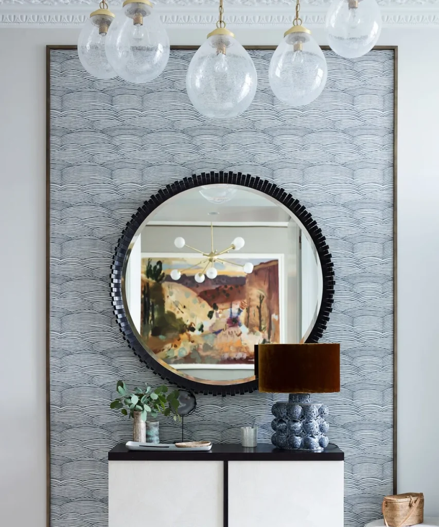 “Elegant bedroom featuring large wall mirror reflecting natural light.”