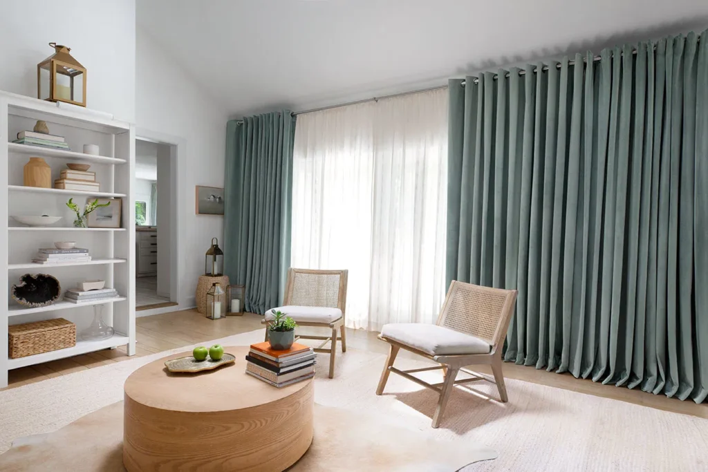Layered window treatment combining sheer curtains with blackout drapes in a modern room.